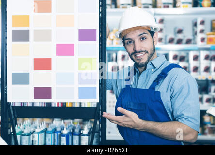 Glückliche Arbeiter in der Nähe von Stand mit Proben in Farbe Speicher Stockfoto