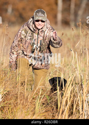 Eine Frau mit einem schwarzen Labrador Retriever an einem Herbsttag für die Jagdsaison Stockfoto