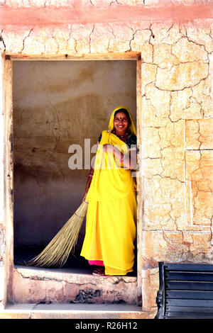 Ein Arbeitnehmer, mit Besen in der Hand, steht für einen Augenblick Touristen in Amber Fort, Jaipur zu beobachten Stockfoto