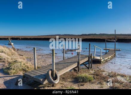 Eine alte, klapprige baufälligen Jetty at morston Creek und Hafen an der Küste von Norfolk mit einem blauen Himmel. Stockfoto