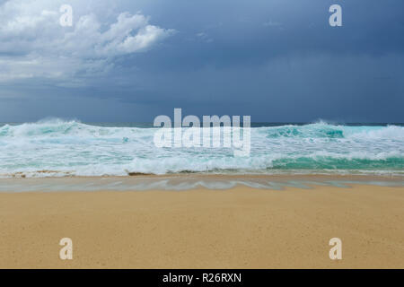 Marine mit großen Wellen des Ozeans waschen über Sandstrand mit dunkelgrauen Himmel oben. Stockfoto