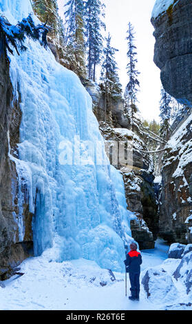 42,749.08968 Frau in einer tiefen Winter schneebedeckten zugefrorenen Fluss Canyon (Maligne River Canyon) suchen Bei Frozen eisigen Mauern & Eisfälle Stockfoto