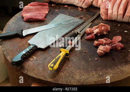 Butcher Block Holztisch mit Fleisch Cleaver Messer und honen Stahl. Schneiden Sie Steaks auf Schneidebrett. Stockfoto