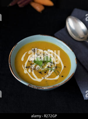 Karotten Suppe mit Sahne und Knoblauch, Schnittlauch und Knoblauch, schwarz Stockfoto