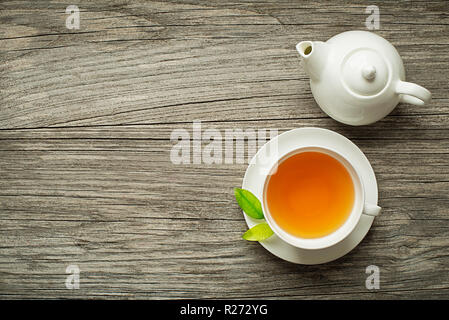 Tasse grün und Kräuter Tee serviert mit Kaffee Topf auf hölzernen Tisch Stockfoto