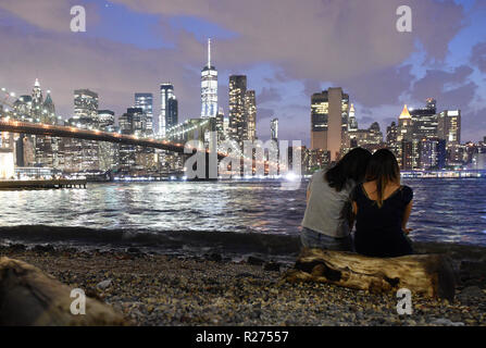 Menschen in Brooklyn Bridge Park genießen am Abend Blick auf den Financial District in Lower Manhattan. Stockfoto