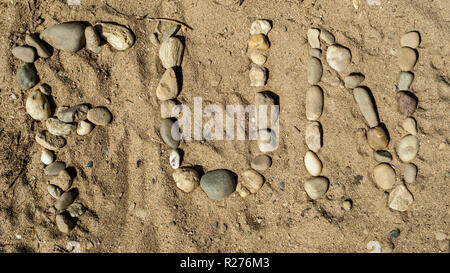 Das englische Wort für Spaß, Spaß mit Kiesel Steinen in den Sand gelegt Stockfoto