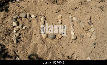 Das englische Wort für Spaß, Spaß mit Kiesel Steinen in den Sand gelegt Stockfoto