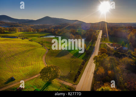 Luftaufnahme von hinten beleuchtete Straße in Georgien Berge mit Sonnenstrahlen. Stockfoto