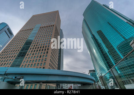 Minato Bezirk, Tokyo, Japan - 19 August 2018: Yurikamome Linie durch Wolkenkratzer, Gebäude in der Nähe von Higashi-Shimbashi Bereich. Shiodome Tower, Royal Park Hot Stockfoto