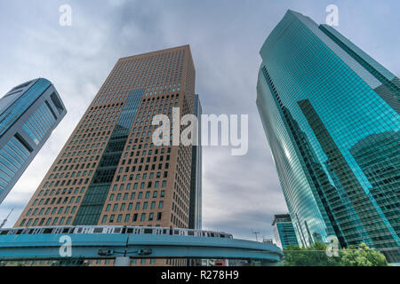 Minato Bezirk, Tokyo, Japan - 19 August 2018: Yurikamome Linie Zug durch Wolkenkratzer, Gebäude in der Nähe von Higashi-Shimbashi Bereich. Shiodome Tower, Stockfoto