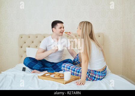 Ein junges Paar ist beim Frühstück am Morgen im Bett. Stockfoto