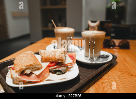 Frühstück Snack - Kaffee Latte und bocadillo Sandwich am Tisch in einem Cafe Stockfoto