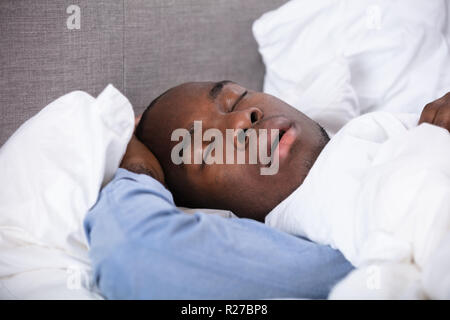 Porträt einer jungen afrikanischen Mann schlafend auf dem Bett Stockfoto