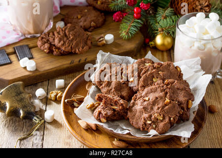 Gebackene Weihnachtsplätzchen. Hausgemachten Schokoladenkekse mit Muttern auf einer hölzernen Tisch. Stockfoto