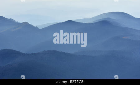 Friedliche blau Natur Hintergrund mit nebligen Bucegi Bergen in den Karpaten von Cota 2000 gesehen, Sinaia, Rumänien Stockfoto