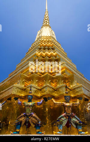 Bangkok, Thailand: Guarding Yaksha Daemon Statuen an der goldenen Chedi (Stupa) im Wat Phra Kaew oder der Tempel des Smaragd Buddha innerhalb der Mauern Stockfoto