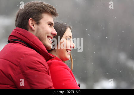 Seitenansicht Portrait von ein glückliches Paar beobachten Schnee im Winter Stockfoto