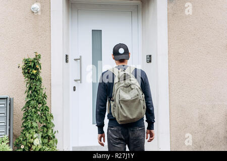 Ein Tourist geht in die Pension oder Herberge, um in ein Zimmer, dass er gebucht oder ein Student mit einem Rucksack kehrt nach seinem Studium am Institut oder auf Urlaub. Stockfoto