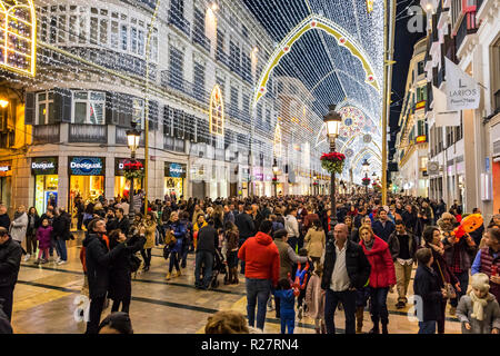 Massen von Menschen zu Fuß auf der Calle Marques de Larios Straße mit Weihnachtsschmuck dekoriert, Malaga, Spanien Stockfoto