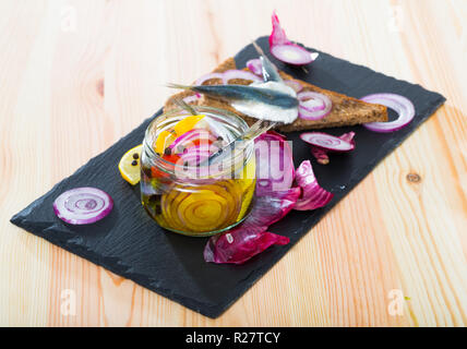 Gebeizt Sprotten in hausgemachten Marinade aus Olivenöl, Essig, Zitronensaft, Meersalz mit Gewürzen, Zwiebeln und Zuckerrüben mit Roggenbrot serviert. Stockfoto