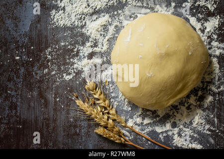Teig. Frischen, rohen Teig Kugel für Brot oder Pizza auf einen dunklen Tisch, backen Hintergrund. Ansicht von oben flach Hintergrund. Kopieren Sie Platz. Stockfoto