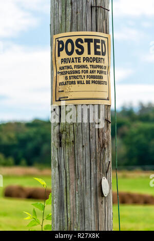 Vertikale Nahaufnahme einer No Trespassing Zeichen auf einem Telefonmast. Stockfoto