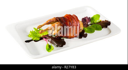 Fotografie der Platte mit gebackenen in Speck Wachtel mit Balsamico Essig. Auf weissem Hintergrund Stockfoto