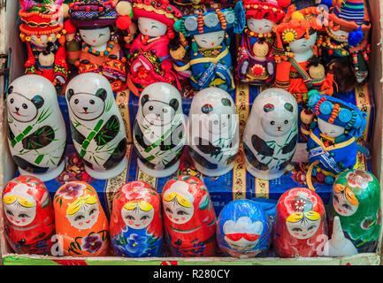 Traditionelle chinesische Puppen und russischen Matrjoschka zusammen mit stilisierten Pandabär nesting Spielzeug auf Anzeige an einen Souvenir Shop durch die Große Mauer in China Stockfoto