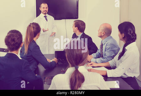 Wissenschaftler präsentieren Bericht während der Sitzung im Büro Stockfoto