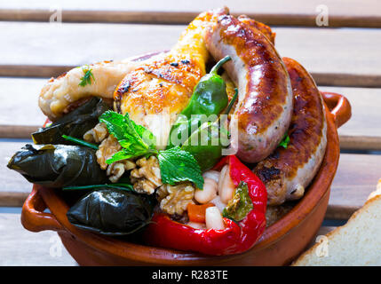 Teller mit leckeren bulgarischen kapama mit Trauben Brötchen, Wurst, Hähnchen und gefüllte Paprika Stockfoto