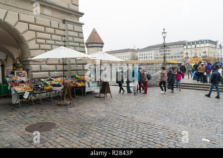 Luzern, LU/Schweiz - vom 9. November 2018: Die vielen geschäftigen Fußgängern und Passanten und Menschen über eine Brücke und einen Marktplatz mit Obst und Gemüse Stockfoto