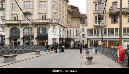 Luzern, LU/Schweiz - vom 9. November 2018: Die vielen geschäftigen Fußgängern und Passanten und Menschen über eine Brücke und einen Marktplatz mit Obst und Gemüse Stockfoto