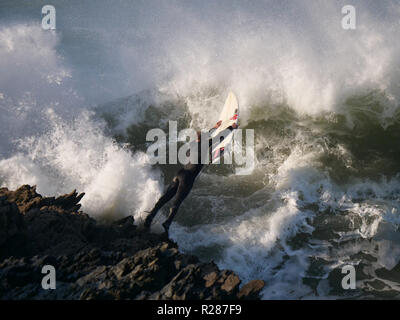 Big Wave UK surfen und gefährlichen Felsen Stockfoto