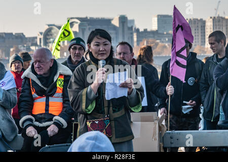 London, Großbritannien. 17. November 2018. Eine mongolische Frau spricht auf die Blackfriars Bridge, einer von fünf Brücken über die Themse in einem nicht blockiert - gewaltsame Rebellion gegen die Regierung für strafrechtliche Untätigkeit auf Klimawandel und ökologischen Kollaps auf Kurs, um das menschliche Leben verbindliche Maßnahmen die CO2-Emissionen zu Net Zero bis 2025 und Energieverbrauch zu senken, die mit einer Bürgerversammlung, um die Änderungen zu beaufsichtigen und wirkliche Demokratie zu schaffen. Das Aussterben der Rebellion, die durch die steigenden Netzwerk fordert eine grundlegende Veränderung unserer politischen und wirtschaftlichen System gut zu maximieren und den Schaden minimieren. Peter Mar Stockfoto