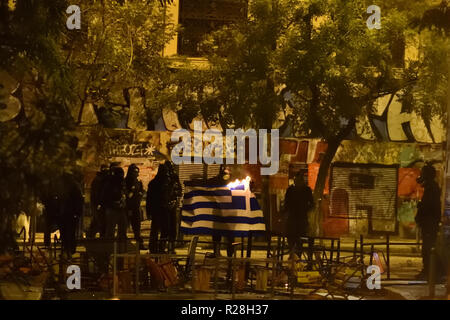 Athen, Griechenland. 17. Nov 2018. Die Demonstranten eine griechische Flagge auf Feuer während der Auseinandersetzungen mit der Polizei nach einem März 1973 Athen Fachhochschüler Aufstand gegen das Militärregime in Athen, Griechenland zu gedenken. Credit: Nicolas Koutsokostas/Alamy Leben Nachrichten. Stockfoto