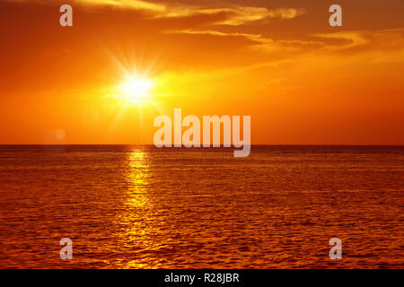 Bunte leer Seascape mit glänzenden Meer über bewölkten Himmel und Sonne bei Sonnenuntergang in Cozumel, Mexiko Stockfoto