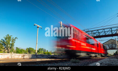 Red Train bei hoher Geschwindigkeit unterwegs an einem sonnigen Tag ohne Wolken Stockfoto