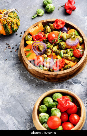 Herbst Salat. Gebratenes Gemüse. Salat aus Kürbis, Rosenkohl, Tomaten und Zwiebeln Stockfoto