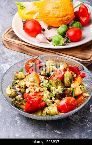 Gebratenes Gemüse. Herbst Salat. Salat aus Kürbis, Rosenkohl, Tomaten und Zwiebeln Stockfoto