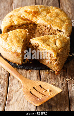 In Scheiben geschnittene Hausgemachte tourtiere Pie mit Schweinefleisch, Kartoffelpüree und Gewürze close-up auf dem Tisch. Vertikale Stockfoto