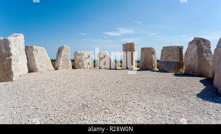 Ein Ring der modernen stehende Steine aus Portland Stein erinnert an alte Steinkreise, Farmhouse, Portland, Dorset, England. Stockfoto