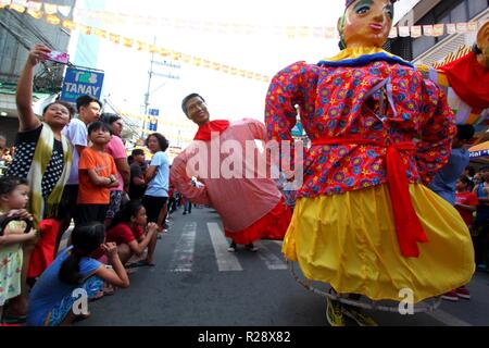 Tourist, selfie Bild während der Higantes (Giant) Bildnis marschiert auf den Straßen Stadt Angono Provinz Rizal am 18. November 2018. Higantes (Giant) Festival gefeiert November in der Stadt Angono, Provinz Rizal in den Philippinen San Clemente, dem Schutzpatron der Fischer zu Ehren. Das Festival bietet eine Parade von Hunderten von higantes, Pappmaché Riesen. Higantes (Giant) sind Marionetten als Mann oder Frau in verschiedenen Kostümen erbracht wurden; ihr Gesicht gibt einen eindrucksvollen Blick, die Hände auf die Hüften. (Foto von Gregorio B. Dantes jr./Pacific Press) Stockfoto