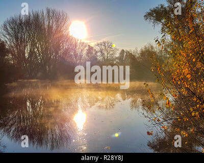 Die Reflexion der aufgehenden Sonne auf der Foggy River Stockfoto