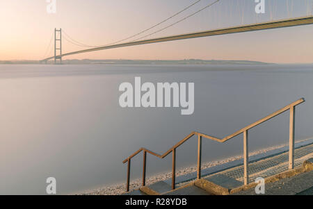 Humber Bridge über der Mündung als Morgendämmerung bricht bei Flut im Herbst, Yorkshire, Großbritannien. Morgen im Herbst, Yorkshire, Großbritannien. Stockfoto