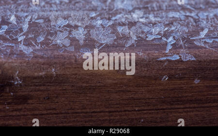 Schneekristalle auf ein Stück Holz Stockfoto