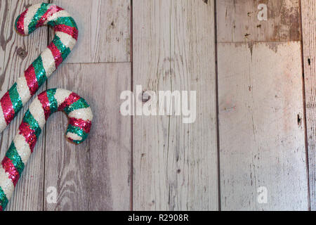 Weihnachtsfeiertag flatlay mit glitzerndem Zuckerstangen in Teal und Rosa mit Schnee fällt auf Holz- Hintergrund Stockfoto