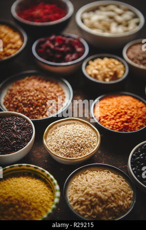 Verschiedene superfoods in kleinen Schüsseln auf dunklen Rusty Hintergrund Stockfoto