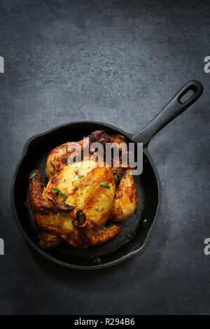 Kraut masala geröstete Cornish Hen/ganze mini Huhn Thanksgiving, Weihnachten Mahlzeit Draufsicht auf dunklem Hintergrund Stockfoto