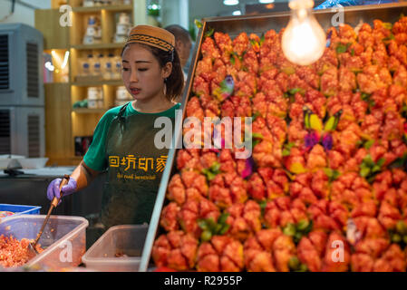 Xi'an, Provinz Shaaxi, China - 10.August 2018: Frau verkaufen Granatapfel in einem muslimischen Vorort Street Market Stockfoto